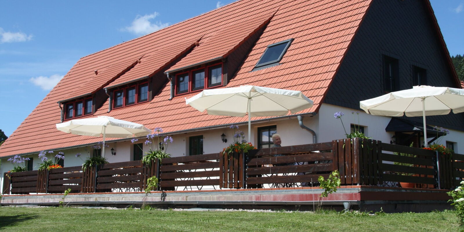 Terrasse mit Sonnenschirmen, dahinter das Café Ober der Eller