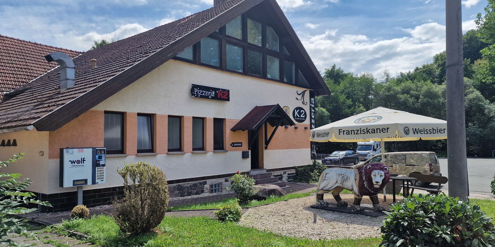 Aussenbereich mit Sonnenschirm und Dekolöwen