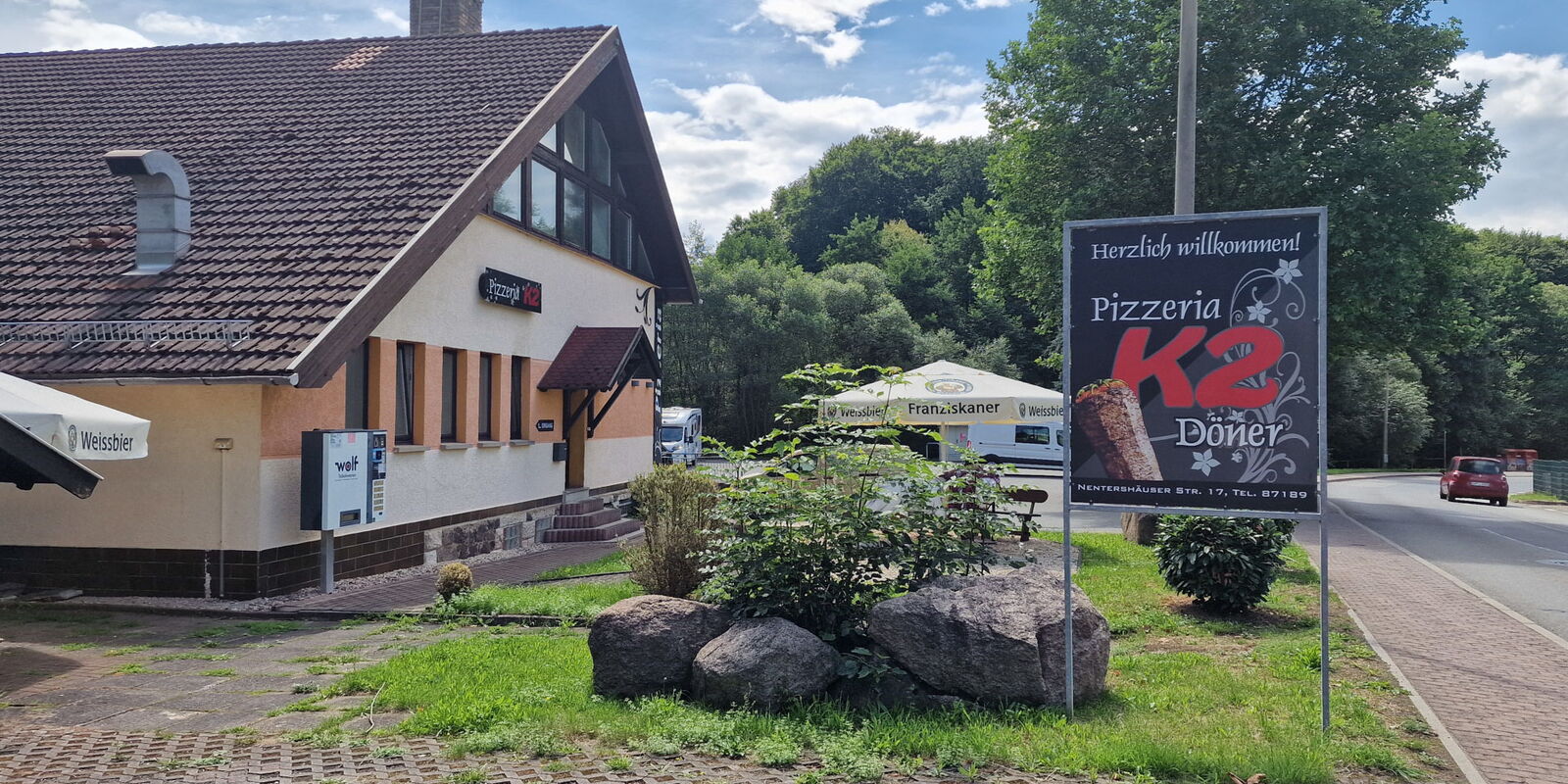 Aussenbereich Pizzeria mit Werbeschild
