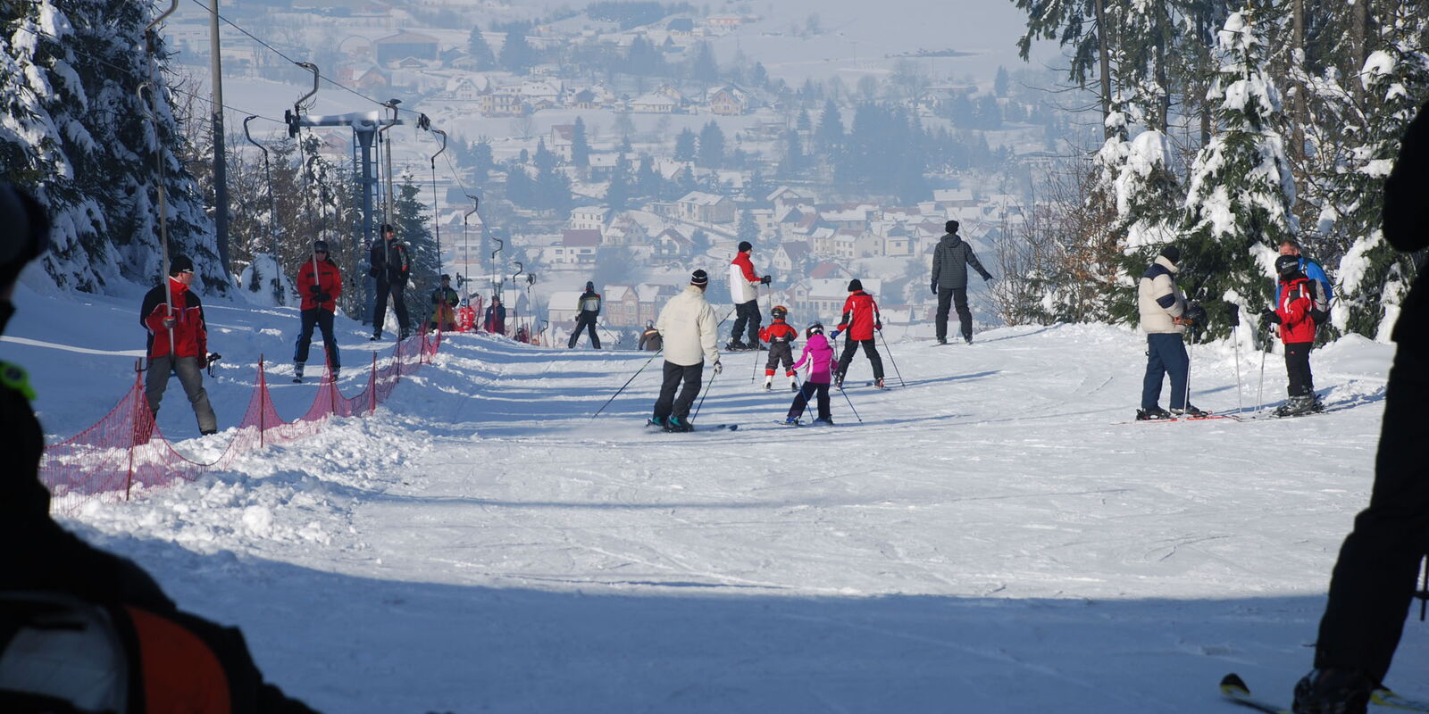 Familien mit Skiern am Abfahrtshang